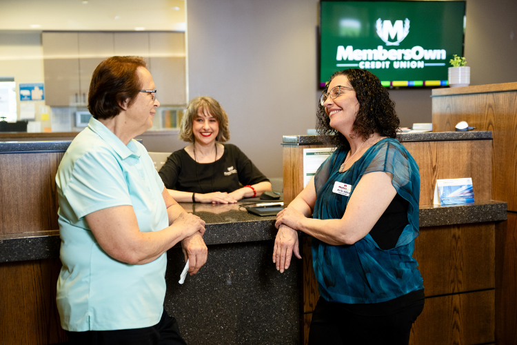 MOCU staff smiling with member in lobby